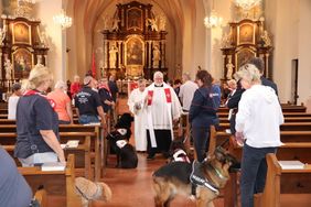 Foto: Malteser - Gottesdienst mit Hund in der Kirche St. Nepomuk in Hadamar. Beirksdekan Pfarrer Fuchs segnet die Ehrenamtlichen und ihre Tiere.